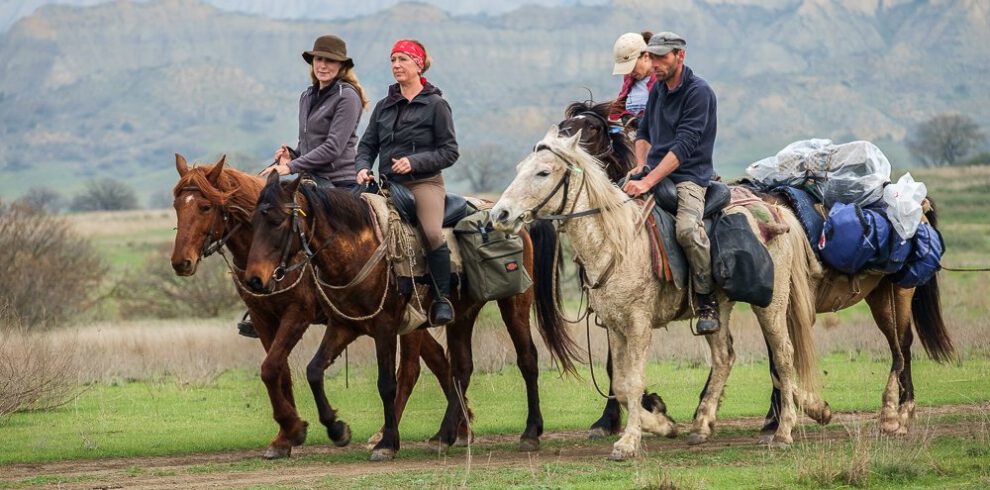 Photo collage of the Horseback Riding Tour Vashlovani Georgia: wild horse herd, flock of sheep with shepherd, Tushetian horses at the ranch, riding group in the steppe and overview map of the route from Tbilisi to Vashlovani National Park