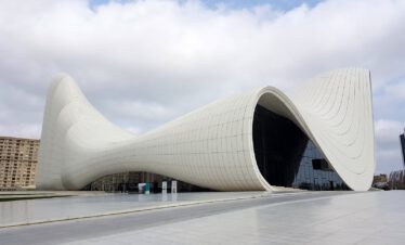 The white curved Heydar Aliyev Center in Baku designed by Zaha Hadid under a cloudy sky, Azerbaijan