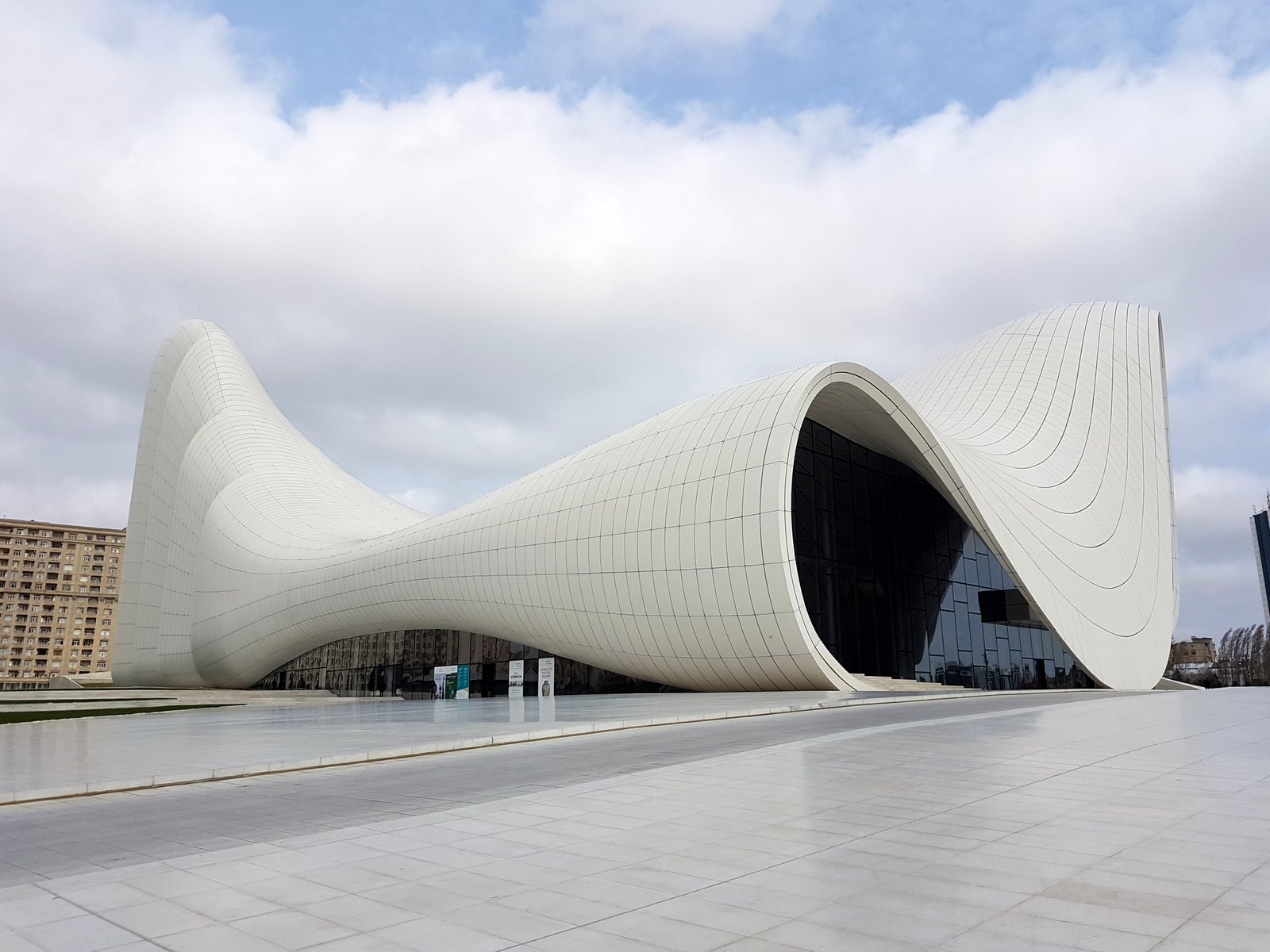 The white curved Heydar Aliyev Center in Baku designed by Zaha Hadid under a cloudy sky, Azerbaijan
