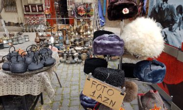 Souvenir stall in Baku's old city with traditional Caucasian papakha hats and Soviet military insignia, Azerbaijan
