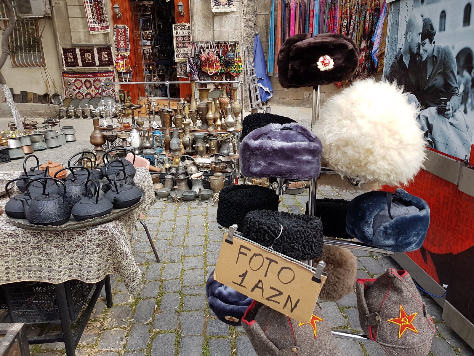 Souvenir stall in Baku's old city with traditional Caucasian papakha hats and Soviet military insignia, Azerbaijan