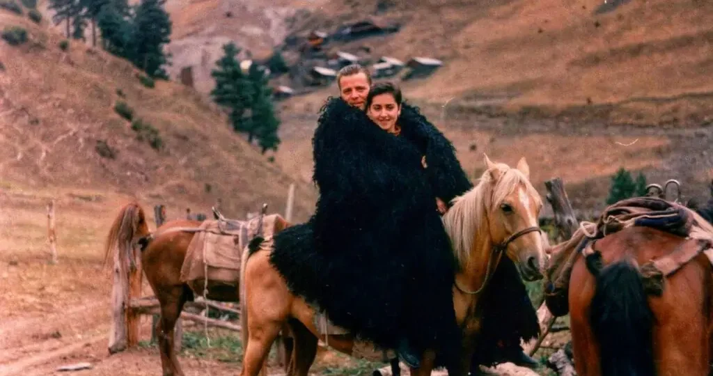 Heiner and Teona Buhr on a horse in the mountains of Tusheti, wearing traditional Georgian felt cloaks, Georgia 1998
